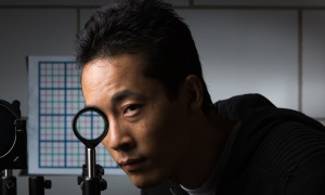 Doctoral student Joseph Choi is pictured with a a multidirectional `perfect paraxial’ cloak using 4 lenses.Credit: University of Rochester Newscenter